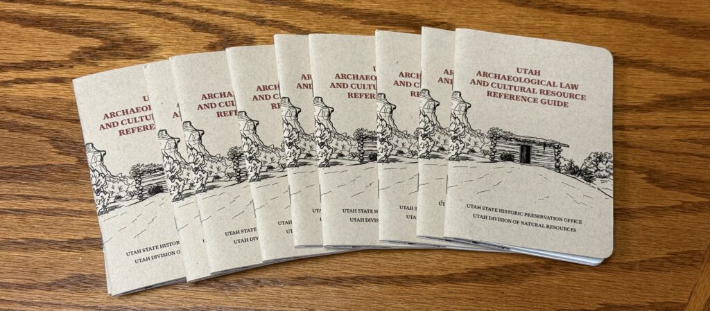Seven booklets titled Utah Archaeological Law and Cultural Resource Reference Guide on wood floor.